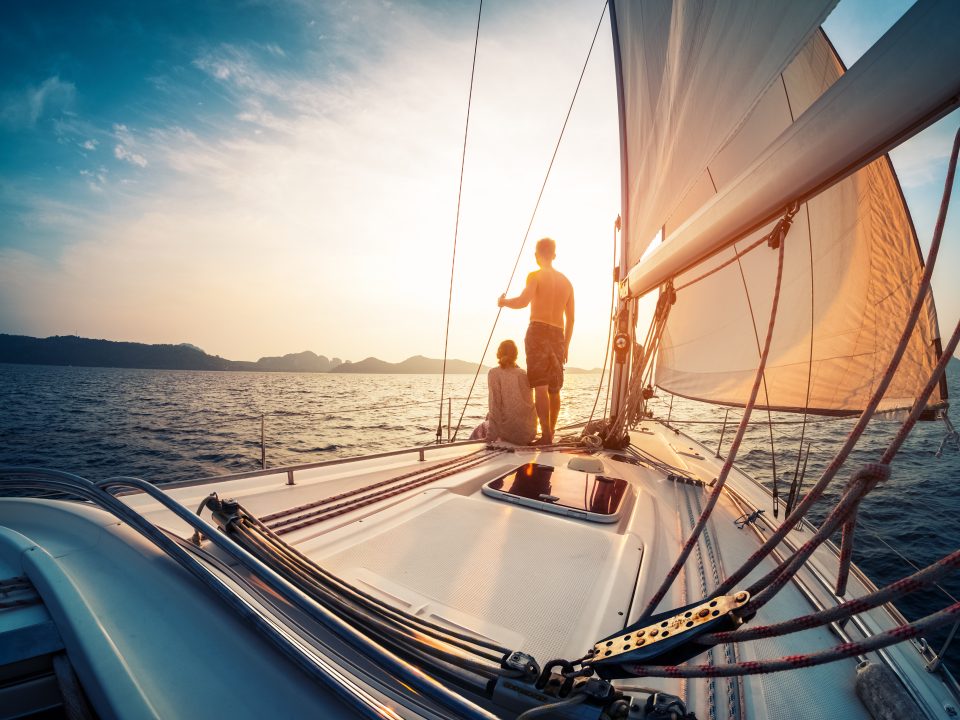 Couple,Enjoying,Sunset,From,The,Deck,Of,The,Sailing,Boat